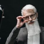 Innovation Frontier: Ai - Smiling Elderly Man in Gray Suit Holding his Eyeglasses